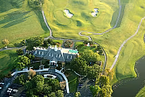 Aerial view of Eagle Trace Golf Club with lush green fairways, sand traps, a large clubhouse, and scenic Florida landscape.