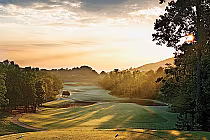 Scenic view of Ridge Course at Oxmoor Valley golf course during sunset, featuring lush green fairways, trees, and a peaceful landscape.