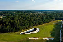 Aerial view of Eagle Landing Golf Club in Florida featuring lush green fairways, sand bunkers, and dense surrounding forest.