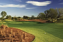 Beautiful view of Mystic Dunes Golf Club with lush green fairways, trees, and a clear sky, showcasing Florida's distinctive golf course.