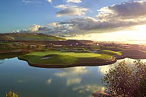 Scenic view of Arrowood Golf Course with lush green fairways, water hazards, and rolling hills at sunset in Oceanside.