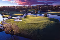 Aerial view of Innisbrook North Course at sunset, featuring lush green fairways, water hazards, and trees on a scenic golf course.