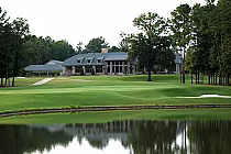 Scenic golf course at Timberline Golf Club with a large clubhouse, lush green fairways, trees, and a water hazard.