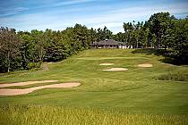 Scenic view of Timber Ridge Golf Course with lush green fairways, sand bunkers, surrounded by trees and a clubhouse in Brighton.