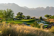 Scenic view of Rams Hill Golf Course with lush green fairways, sand traps, trees, and mountains in the background.