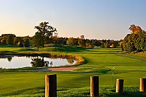 Scenic view of St. Andrews Valley Golf Club in Ontario, featuring lush green fairways, a pond, and autumn-colored trees.