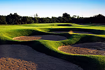 Beautiful golf course with sand bunkers, lush green grass, and a clear sky, near Toronto at Station Creek golf destination.