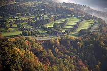 A scenic aerial view of Whirlpool Golf Course in Niagara, featuring lush green fairways, trees, and surrounding fall foliage.