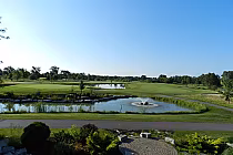 Scenic view of Sutton Creek Golf Club in Ontario with lush green fairways, water hazards, and a clear blue sky.