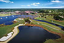 Aerial view of PGA National Resort's Palmer Course featuring lakes, sand traps, lush green fairways, and a clubhouse in the background.