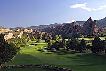Scenic view of Arrowhead Golf Club in Denver, Colorado, featuring a lush green golf course with rocky mountain formations in the background.