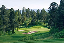 Scenic golf course at The Ridge in Castle Pines North with lush green fairways, trees, and mountain views in the background.