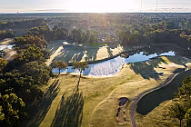 Aerial view of Blackmoor golf course in Myrtle Beach with lush greenery, water hazards, and scenic natural surroundings at sunrise.