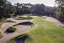 A scenic golf course with sand traps, green fairways, and trees, located at Founders Club in Pawleys Island, USA.