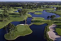 Aerial view of Man O War golf course featuring 18 holes, multiple island greens, water hazards, and lush green fairways.