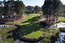 A scenic golf course at Myrtle Beach National with a small island green surrounded by water, trees, and sand bunkers.