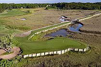 Aerial view of Pawleys Plantation Golf & Country Club with a green, flag, sand trap, and surrounding marshland in Myrtle Beach, SC.