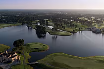 Aerial view of a scenic golf course with water hazards, lush green fairways, and trees, inspired by Scottish links golf in Myrtle Beach.