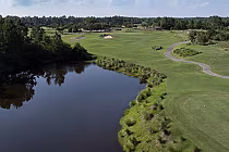 Aerial view of Legends Heathland golf course in Myrtle Beach with lush green fairways, a water hazard, and scenic trees.