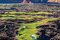 Aerial view of Black Desert Golf Course in St. George, featuring lush green fairways, sand traps, water hazards, and surrounding desert landscape.