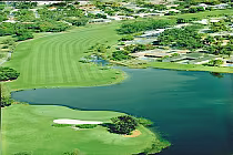 Aerial view of The Club at Emerald Hills golf course with lush green fairways, water hazards, and surrounding residential area in South Florida.