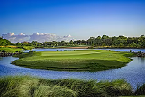 Scenic view of Ocean’s 4 golf course with lush green fairways, water hazards, and tropical trees under a bright blue sky.