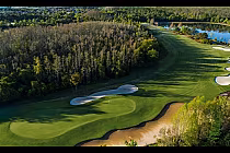 Aerial view of Grand Lakes Orlando Ritz-Carlton golf course with lush green fairways, sand traps, water hazards, and surrounding trees.