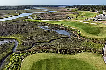 Aerial view of Rivers Edge Golf Club with lush green fairways, sand bunkers, water hazards, and surrounding wetlands.