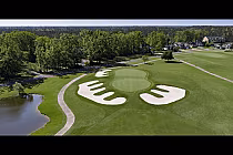 Aerial view of Shaftesbury Glen golf course with green fairways, sand bunkers, a pond, and surrounding trees in a scenic setting.