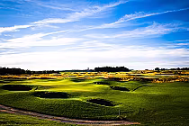 Scenic view of a golf course with lush green fairways, sand bunkers, and a bright blue sky with wispy clouds at Tarandowah Golfers Club.