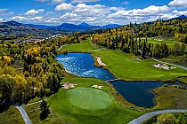 Aerial view of Raven at Three Peaks golf course in Summit County, featuring lakes, green fairways, and surrounding autumn trees with mountains in the background.