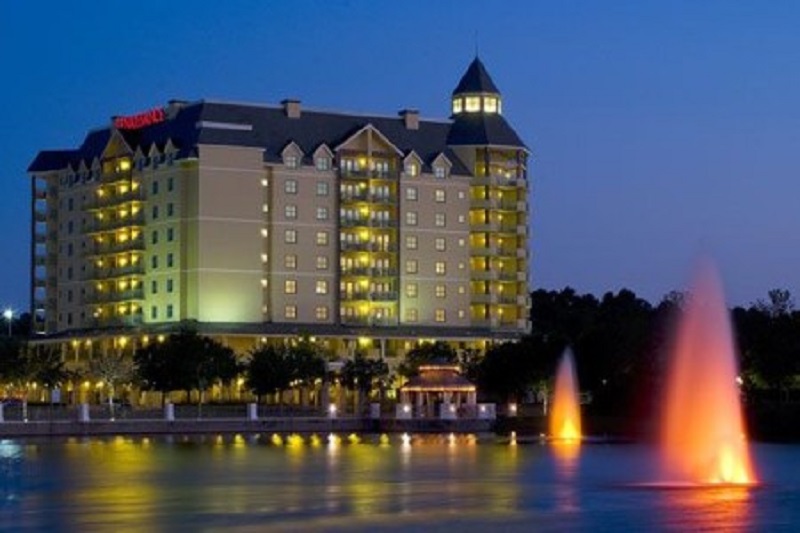 Night view of the World Golf Village Renaissance St. Augustine Resort with illuminated building, water fountain, and reflections.