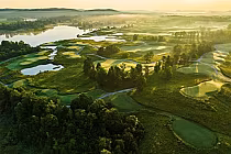 Aerial view of RTJ Silver Lakes golf course with lush green fairways, water hazards, and scenic Appalachian vistas at sunset.