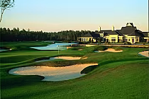 Scenic view of St. Johns Golf Club with lush green fairways, sand bunkers, water hazards, and a large clubhouse in the background.