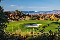 Scenic golf course at The Ledges in St. George with green fairways, sand trap, and desert landscape under a blue sky.