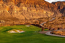 Scenic view of Copper Rock Golf Course in St. George, featuring lush green fairways, sand bunkers, and desert mountains in the background.