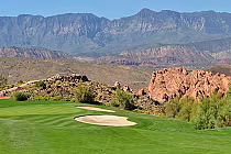 Scenic view of Sky Mountain Golf Course in St. George, featuring lush green fairways, sand bunkers, and rugged mountain landscape.