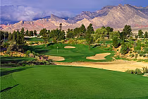 Angel Park Golf Club Mountain Course with lush green fairways, sand bunkers, trees, and mountain views in the background.