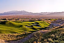 Scenic view of The Wolf golf course at Paiute Resort in Nevada, featuring lush green fairways, sand traps, and desert landscape.