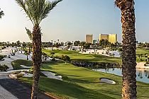 Golf course at Bali Hai Golf Club with lush green fairways, palm trees, water hazards, and Las Vegas Strip skyline in the background.
