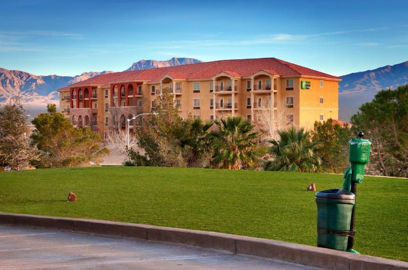 Holiday Inn Express & Suites Mesquite hotel on a hilltop with Virgin Valley views, surrounded by trees and mountains in Nevada.