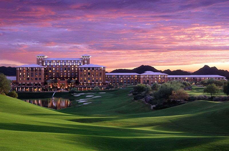 Sunset over Westin Kierland Resort and Spa in Scottsdale, showcasing a luxurious hotel, lush golf course, and scenic mountain backdrop.