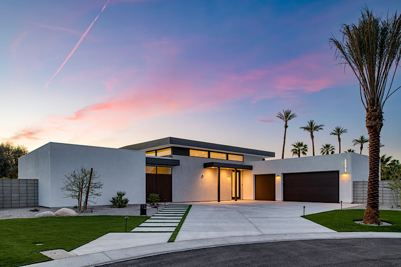 Polo Villa 17 | The Reserve Modern white villa with a flat roof, large windows, palm trees, and a spacious driveway at sunset, located in Polo Villa 17, The Reserve.