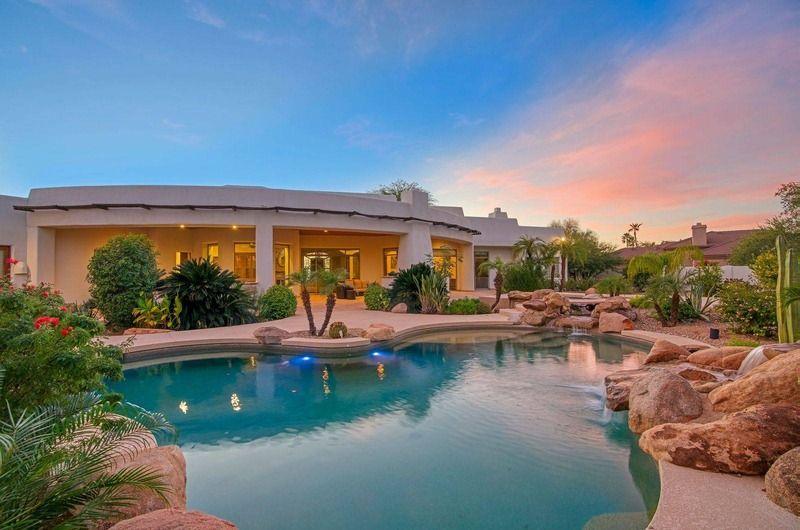 Luxury Scottsdale vacation home with a swimming pool, desert landscaping, and sunset sky, perfect for golf enthusiasts at Estrella Manor.