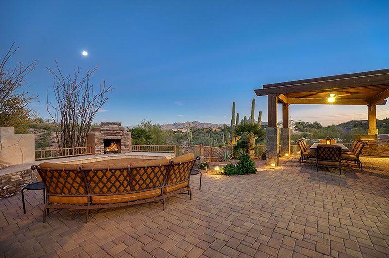 Luxurious outdoor patio at The Refuge in Fountain Hills with a firepit, seating, desert landscape, and mountain views at dusk.