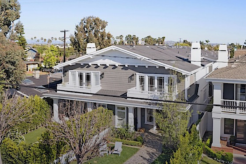 Aerial view of luxury vacation homes in Newport Beach, featuring modern architecture, balconies, and lush greenery, ideal for golf vacations.
