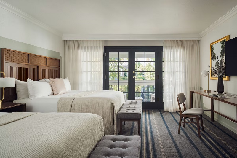 Luxurious hotel room at The Scott Resort & Spa in Scottsdale, Arizona, featuring two beds, a balcony, and elegant decor.