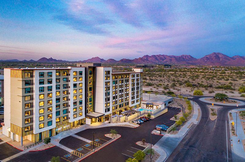 Aerial view of Hyatt North Scottsdale hotel with mountain backdrop, modern architecture, and surrounding desert landscape.